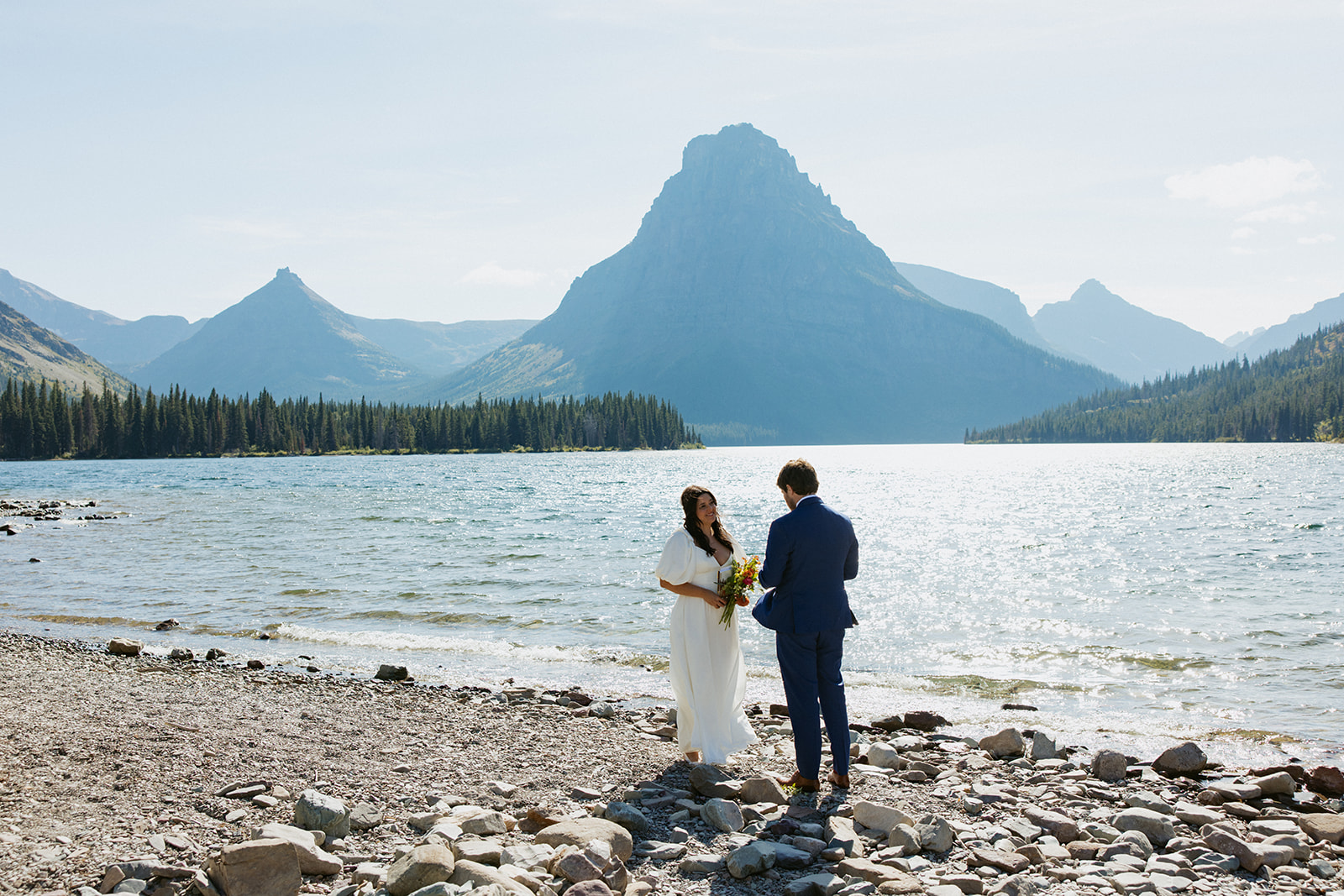 couple exchanging vows on the shoreline of two medicine lake