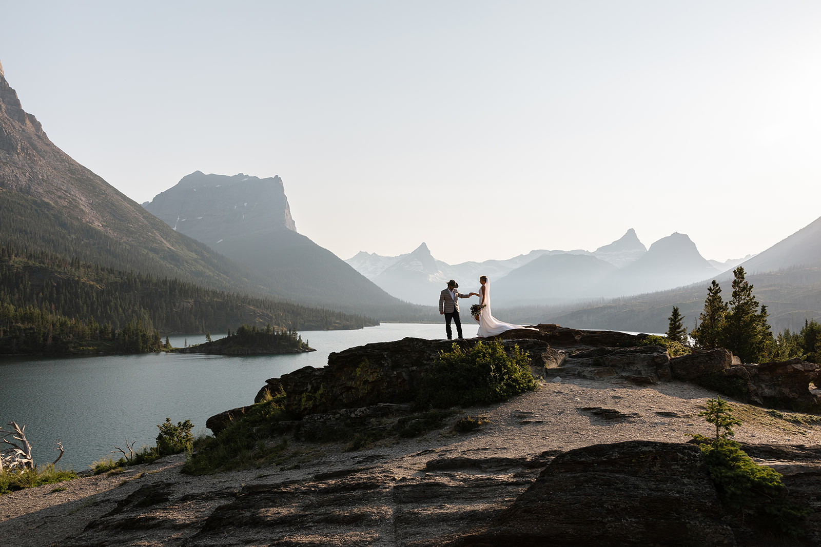 couple having a ceremony on sunpoint which is one of the best elopement locations in glacier park